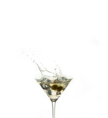 detail of a cocktail glass with an alcoholic preparation of ice and olives. Splash of an ice inside a crystal glass on a white background. drink concept