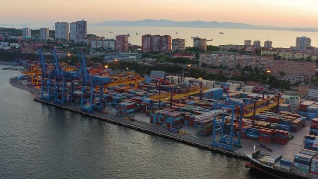 The beautiful peninsula of Shkota (Egersheld) in the rays of the setting sun. Port container terminal, Amur Bay, panoramic view from a drone. Flight over Vladivostok. Russia