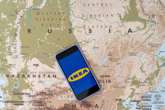 Ikea Logo On The Smartphone Screen On The Background Of The Map Of Russia. The Concept Of Leaving The Ikea Store From Russia. 