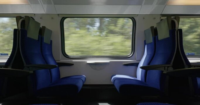 Moving train with empty seats or bench. Inside view, moving landscape out the windows, real time, no people. Swiss SBB public train in Europe