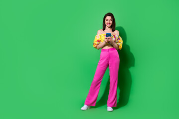 Full length photo of adorable sexy girl dressed off shoulders top writing modern device isolated green color background