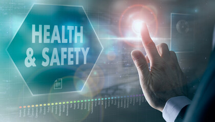 A businessman controlling a futuristic display with a Health & Safety business concept on it.