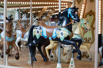 Fototapeta na wymiar Black plastic horse toy close-up, children carousel amusement park