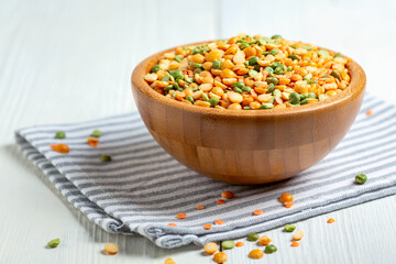 Mixture of dry legumes in a wooden bowl.
