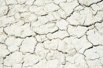Cracked sandy soil surface. Drought broken ground earth.