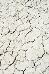 Cracked sandy soil surface. Drought broken ground earth.