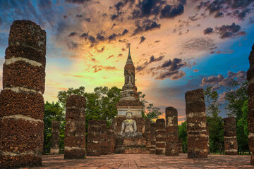 Dramatic sunset on Sukhothai historical park with ruins of Buddhist temple and big Buddha. Travel and discover concepts. - obrazy, fototapety, plakaty