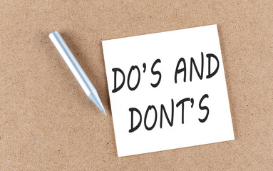 DO'S AND DONT'S text on sticky note on a cork board with pencil ,