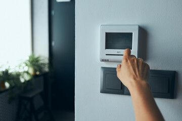 Woman controlling office with digital touch screen panel installed on the wall in office. Concept...