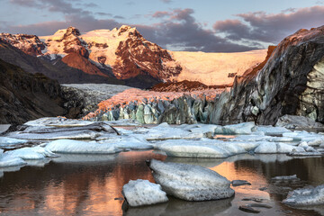 Warm sunlight across the ice and mountains of Svinafellsjokul glacier at sunset., southern iceland. Part of the larger Vatnajokull glacier