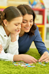 Mother with little daughter collecting  puzzles