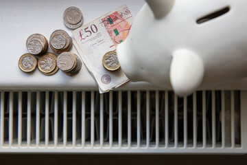Cost of living crisis. Money on a home radiator heater. Rising cost of energy and bills