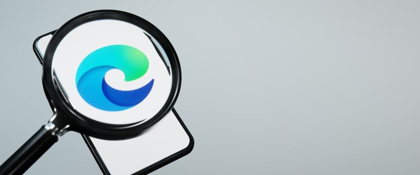 Microsoft Edge logo on smartphone under magnifying glass. Editorial illustration