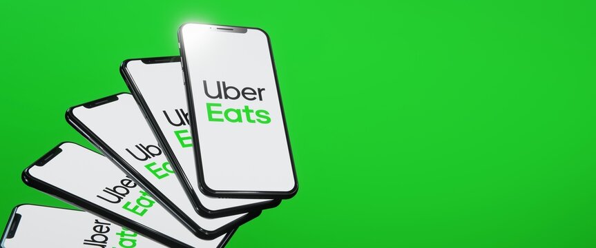 Uber Eats logo displayed on smartphones. Editorial illustration