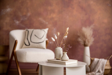 The stylish composition a living room interior with coffee table, vase with dried flowers and...
