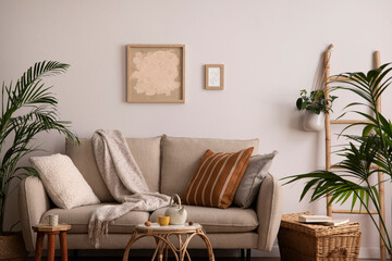 The stylish composition of living room interior with beige sofa with pillow, plaid, coffee table...