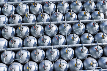 A lot of bottles filled with gas or gasoline are stacked in piles