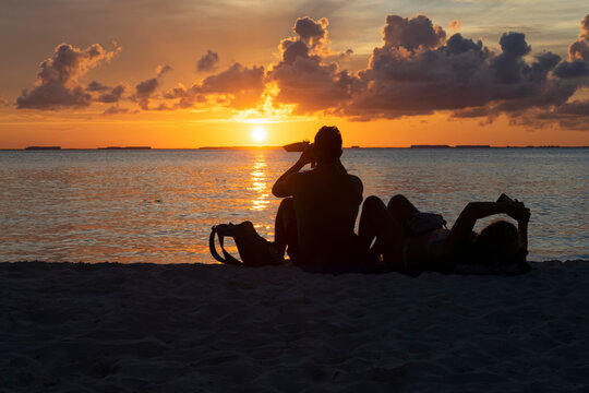 Silhouette of a tourist couple at sunset on a tropical island beach at sunset in Mexico