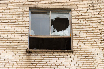 Windows with broken glass on the brick house