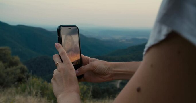Woman hands closeup holding mobile phone on travel to mountains. Family making selfie picture on smartphone on summer hike journey. Happy mother with daughter smile and taking photo