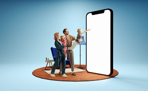 Happy family standing in front of huge 3d model of smartphone with empty white screen isolated on blue background. New app, holiday, travel, ad concept