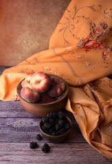 still life with peaches and blackberries, done in brown tones