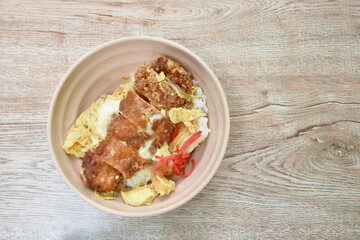 deep fried slice pork with egg or tonkatsu with Japanese pickled vegetable on rice in bowl
