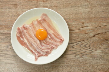 raw slice pork belly arranging topping egg on plate