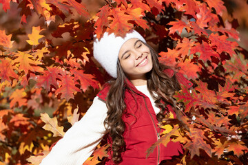 Naklejka na ściany i meble Child teen girl in autumn fall park outdoor, autumn fun kids face. happy kid in hat at autumn leaves on natural background