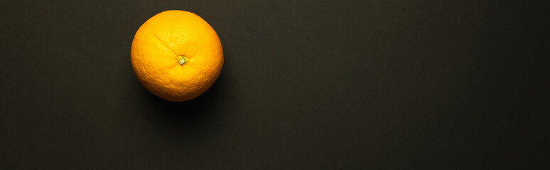 Top view of orange isolated on black, banner.