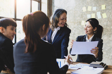 Business meeting. The senior manager talks to employees in the conference room and discuss company project development strategies during the meeting.