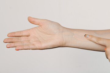 Foundation on the hand of a girl, selection of the color of cosmetics in the store, the correct skin tone