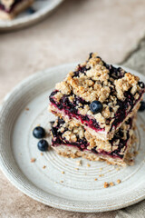 Homemade blueberry crumble bars on a plate for breakfast with napkin close up. Healthy school snack concept