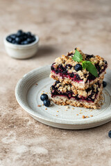 Homemade blueberry crumble bars on a plate decorated with mint. Healthy homemade food concept. Text space