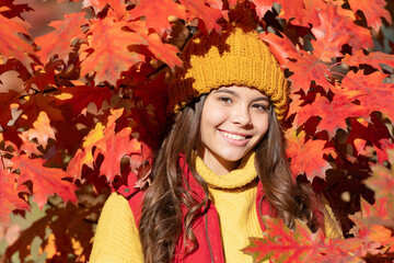Child girl in autumn fall park outdoor, kids fun face. happy kid in hat at fall leaves on natural background