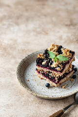Homemade blueberry crumble bars on a plate decorated with mint. Healthy homemade food concept close up. Text space