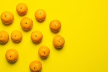 Top view of ripe and organic tangerines on yellow background.