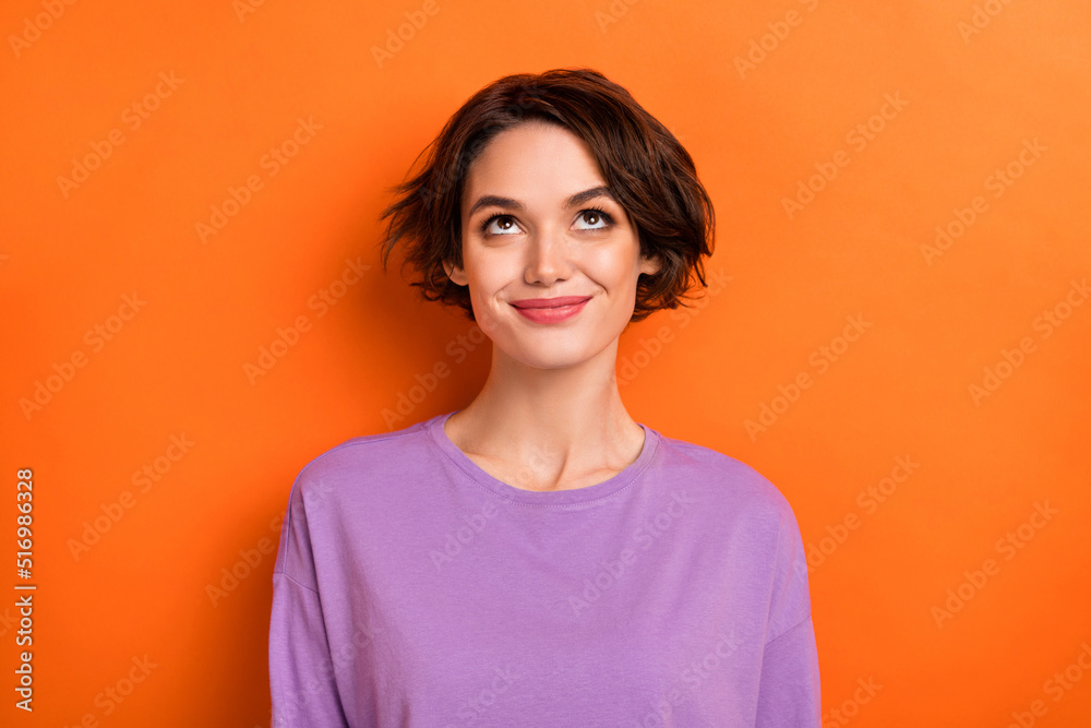 Canvas Prints Photo of adorable thoughtful girl dressed purple pullover looking up empty space isolated orange color background