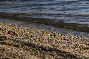 Sea waves breaking on the beach with sand and pebbles