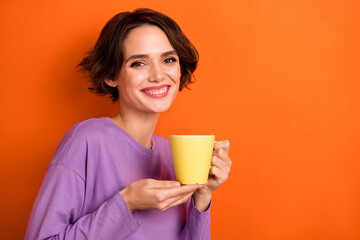 Photo of gorgeous friendly person hands hold fresh coffee cup isolated on orange color background