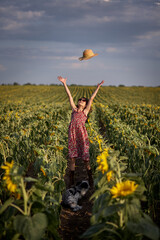 Fototapeta premium Cute girl in a sunflower field.