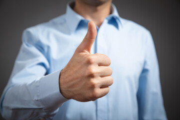 Businessman making a thumbs up gesture.