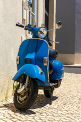 Bright blue moped parked on a European street