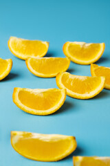 Fototapeta na wymiar Close up view of cut orange pieces on blue background.