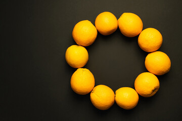 Top view of circle from oranges on black background.