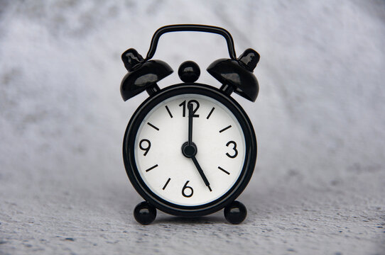 Alarm clock pointing at 5 o'clock with customizable space for ideas or text. Copy space