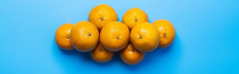Top view of tangerines on blue background, banner.