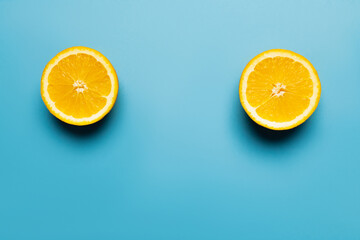 Top view of bright and cut orange on blue background.