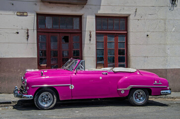 Vintage pink convertible car in an old street of Havana, Cuba - obrazy, fototapety, plakaty