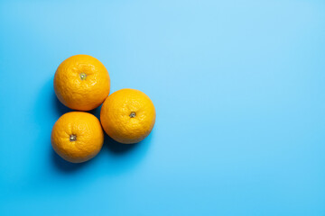 Top view of oranges on blue background with copy space.